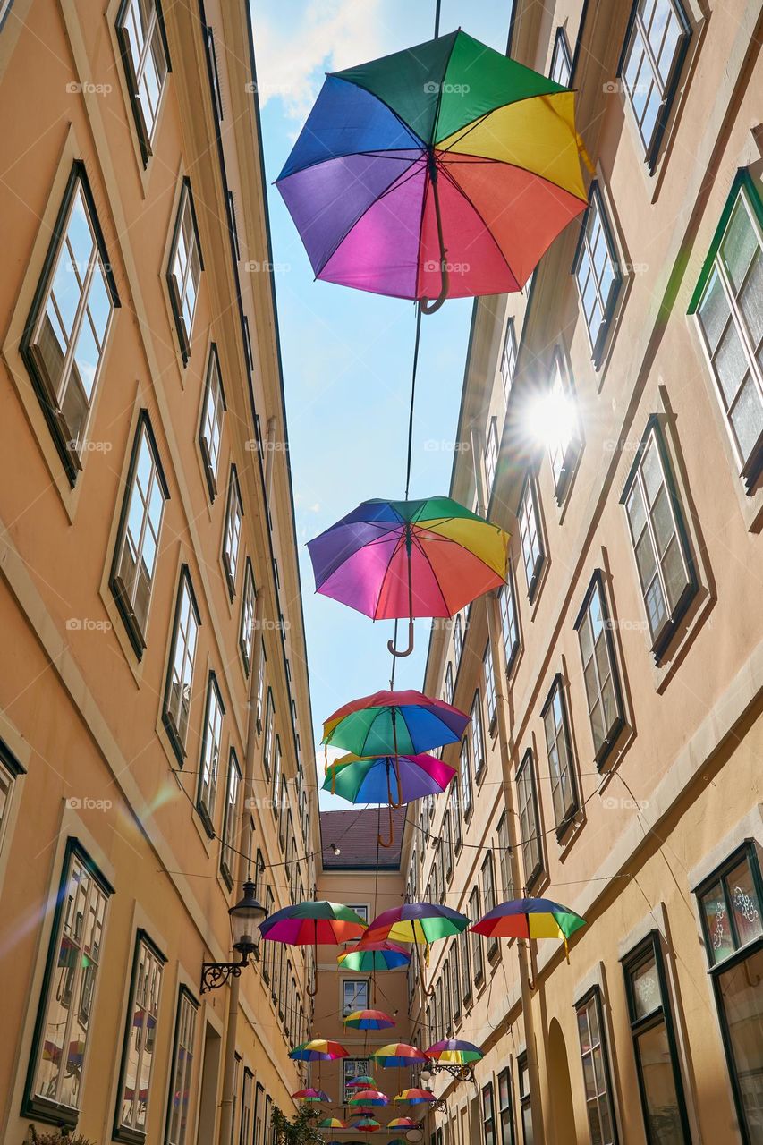 Decorative colourful umbrellas hanging overhead along the street. 