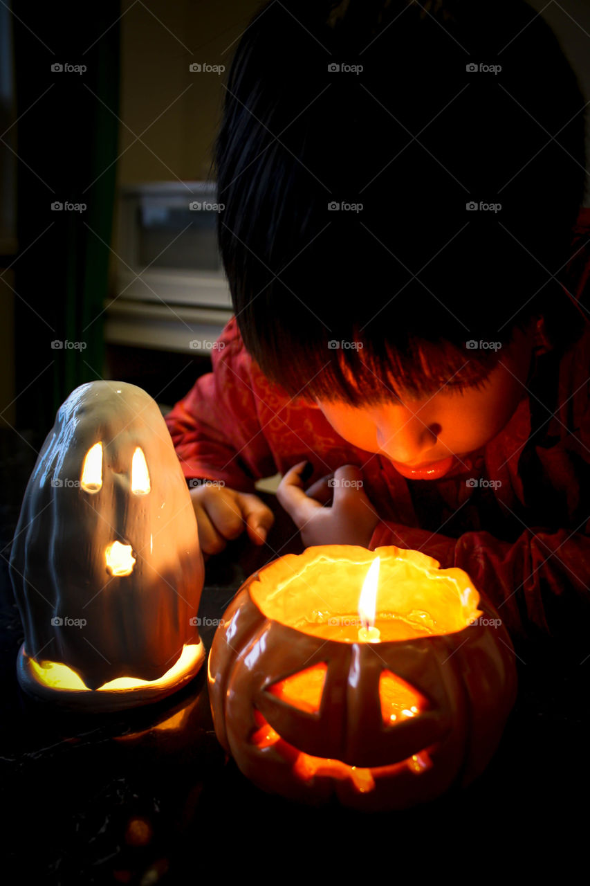 Cute little boy is looking inside jack-o-lantern