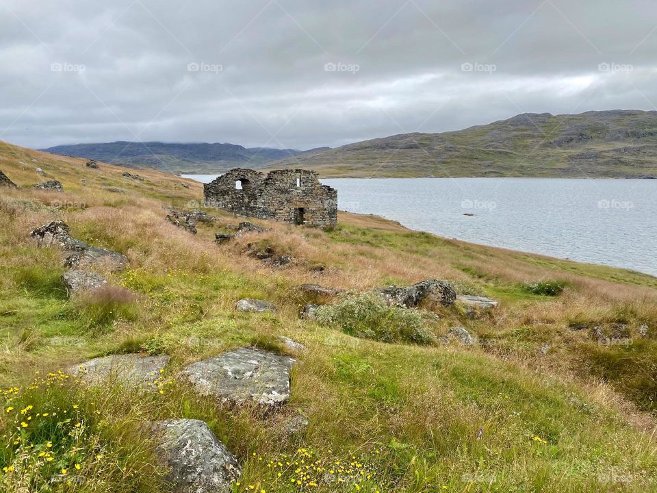 A grassy hill with the remains of a Viking village in the background