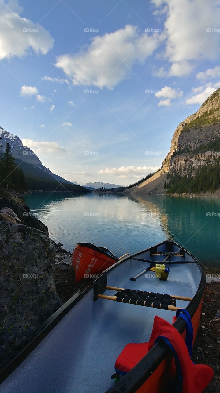 Taken from the back of the iconic Moraine Lake. Canoes resting on the still water in the silent valley.