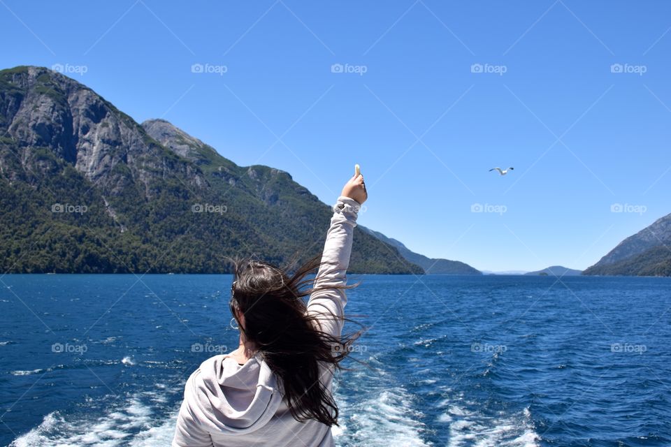 Woman feeding seagulls on a boat