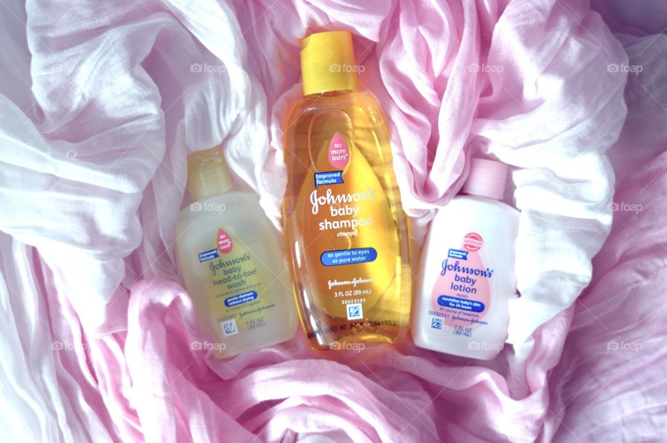 Johnson and Johnson baby products on a pink background flat lay 