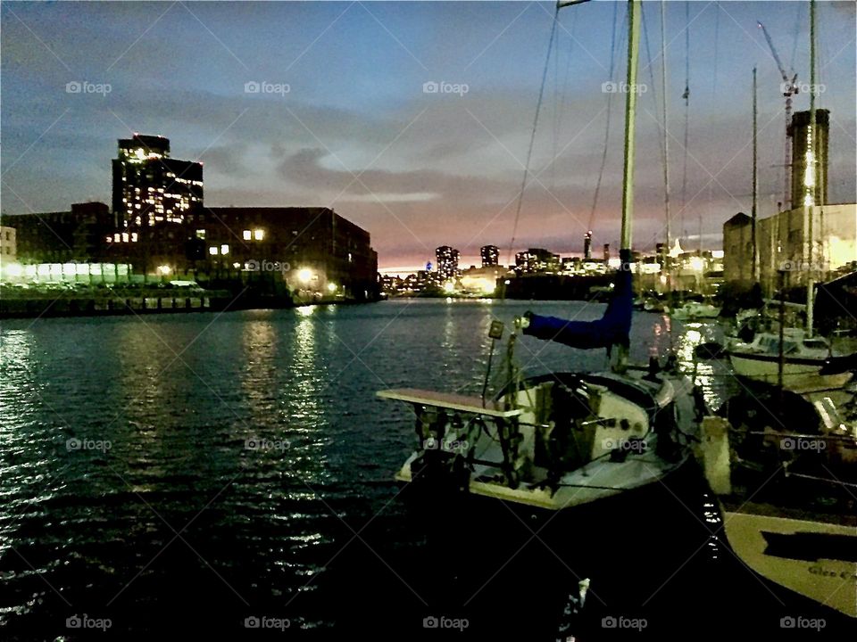 A nighttime shot of the Newtown Creek area in Long Island City, Queens, NY with the illuminated skyline of Queens as well as of Manhattan in the far distance photographed in late 2021. Hypnotic Productions
