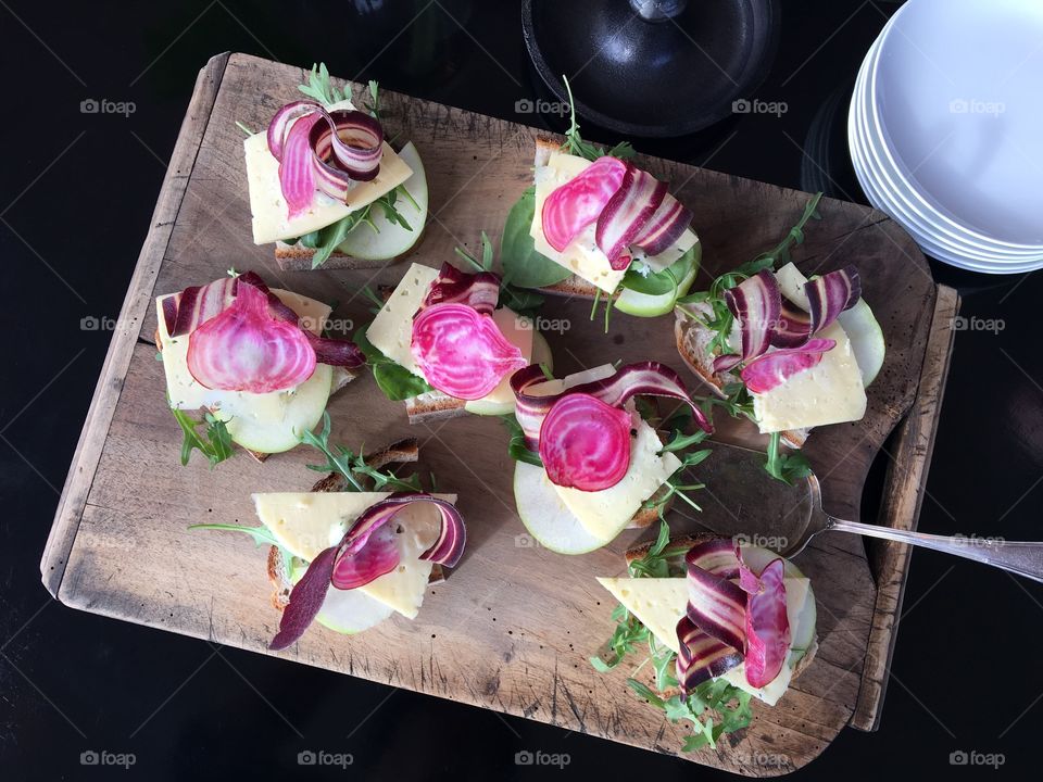 Lovely cheese sandwishes with polka beetroots on cutting board