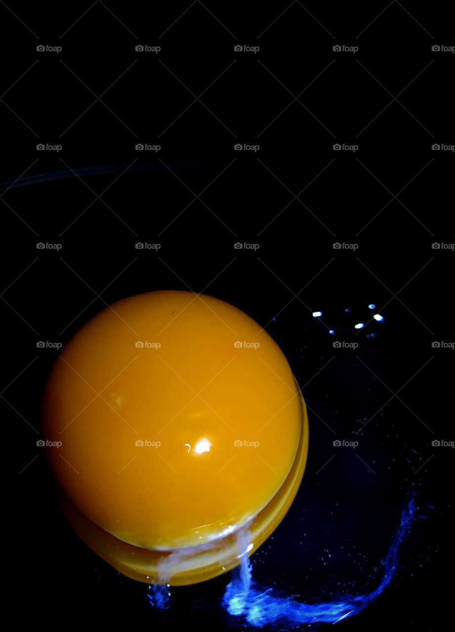 Contrast.  Orange and blue.  Orange egg yolk and bluish egg white on a mirror surface on a black background