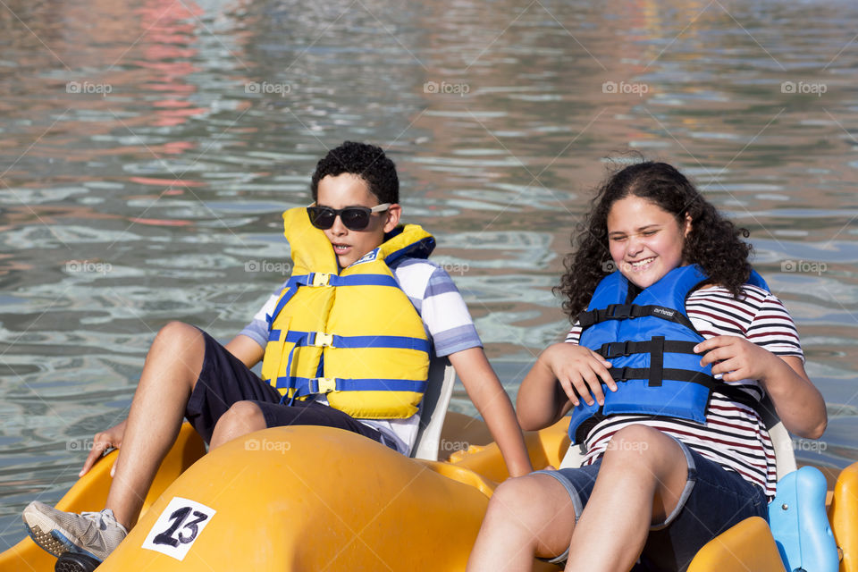 Siblings paddling boat