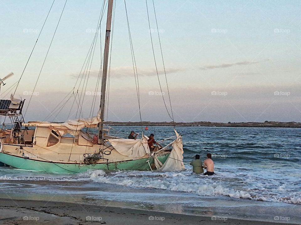 sailboat shipwrecked on the beach