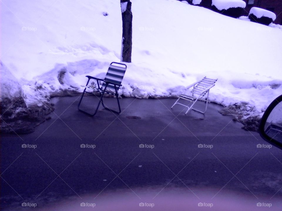 lawn chairs saving parking spots in snow