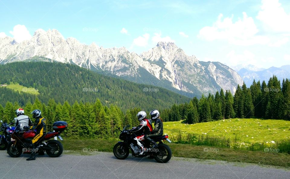 Italian bikers discovering the awesome view on Dolomiti at Sella Razzo, Friuli Venezia Giulia region, Italy