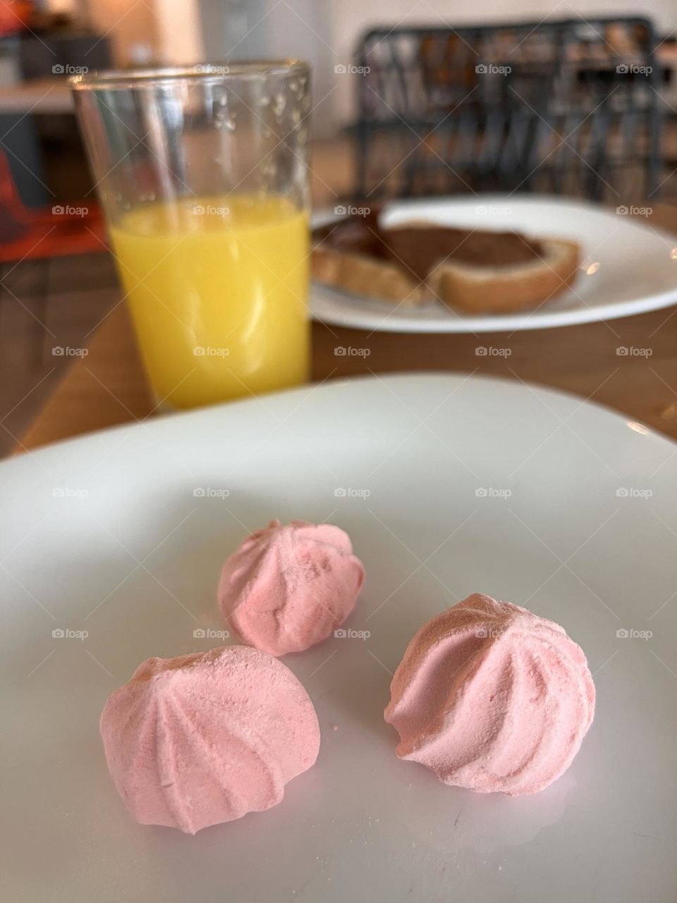 Three pink meringa sweet with orange juice 