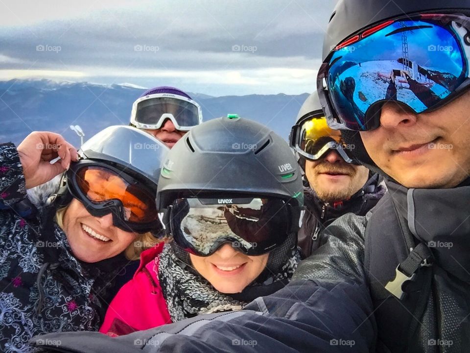 Group selfie of friends wearing ski glasses and ski helmets