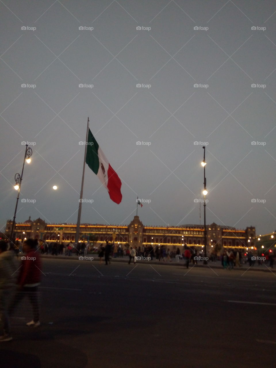 Explanada del zócalo de la ciudad de México con la bandera en lo alto y de fondo Palacio Nacional