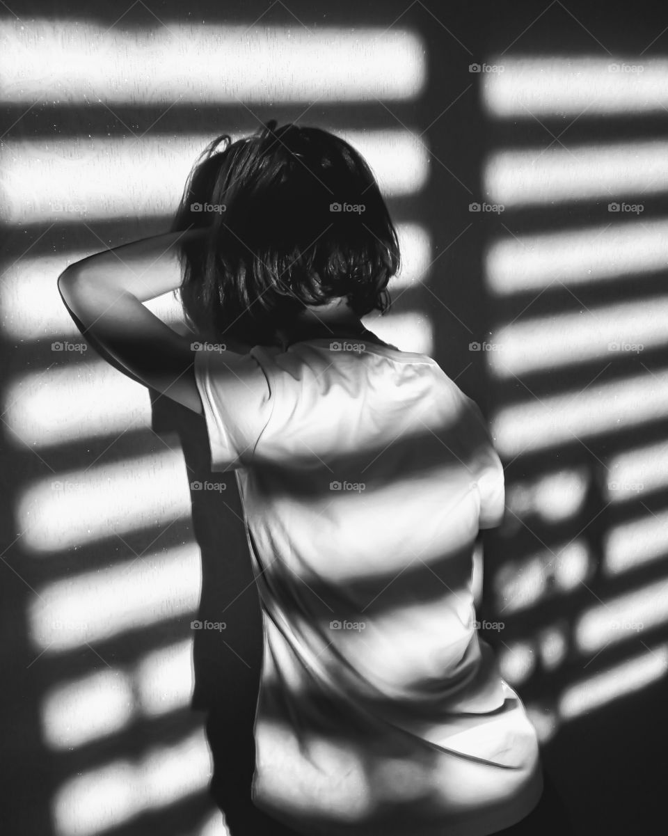 girl stands facing the wall and reflection