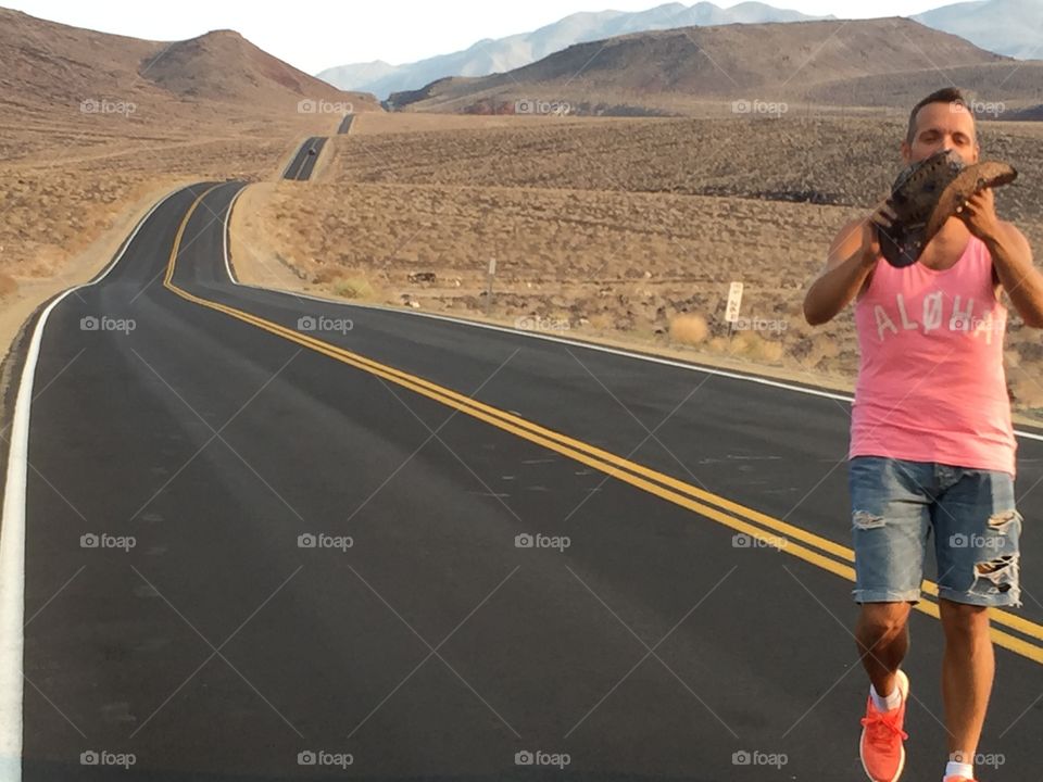 Man holding an object at mountain highway