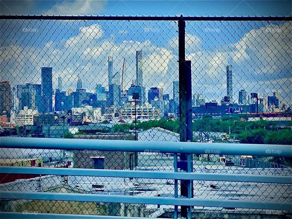 An impression of the „Big Apple“ which is „New York City“ seen from the „BQE“ riding towards „Ft Greene“, Bklyn on a partially overcast day. In the distance the „Manhattan skyline“ can be seen. 2022. Hypnotic Productions