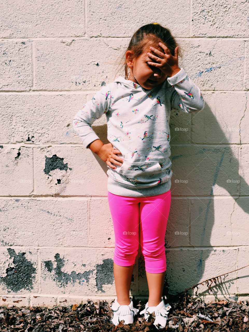 Girl standing in front of dirty wall