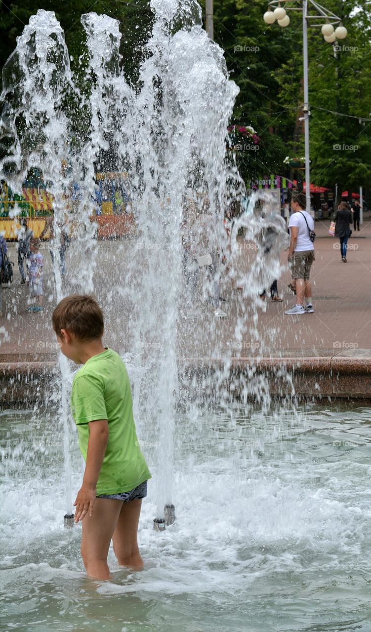 child in water fountain urban, happiness