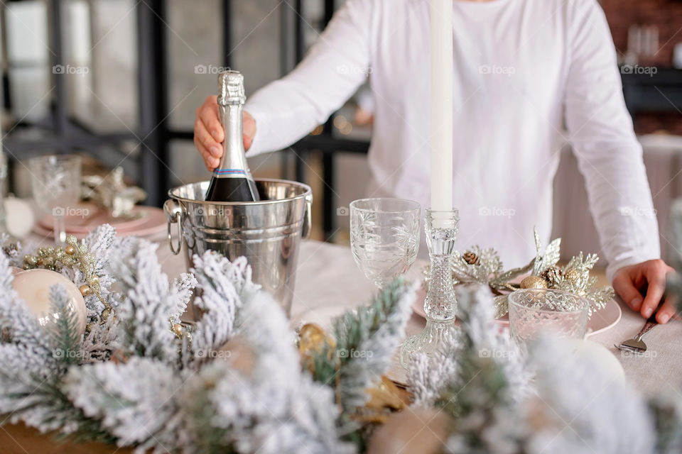 man sets a beautiful decorated winter table for a festive dinner.  Merry Christmas and Happy New Year.