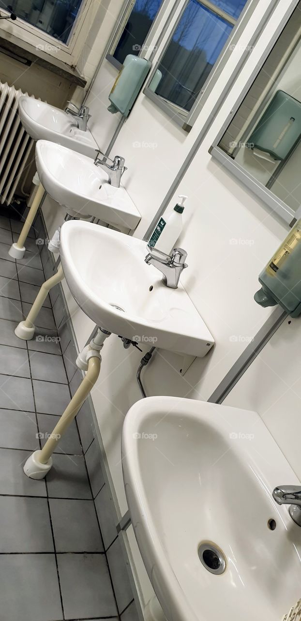 basins on a row in a public toilet