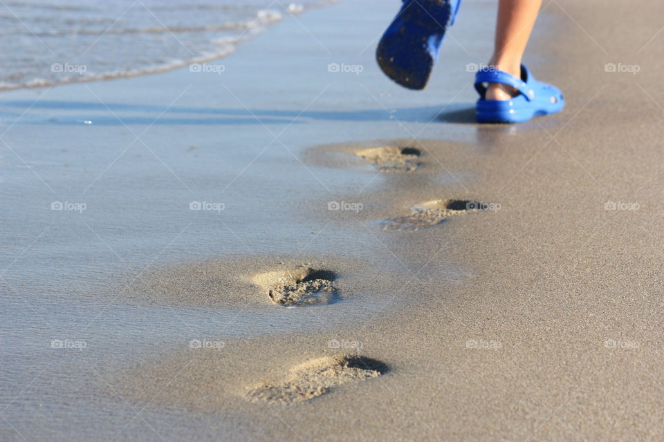 Child’s footsteps in the sand at the beach