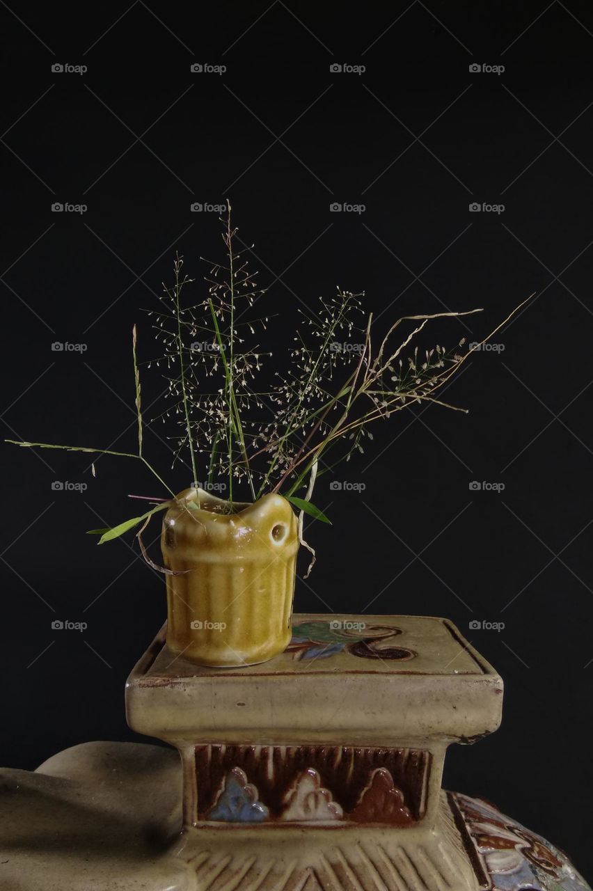 bunch of grass flowers in old ceramic vase