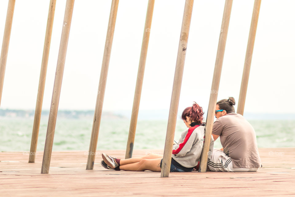 Friends Sitting On The Dock
