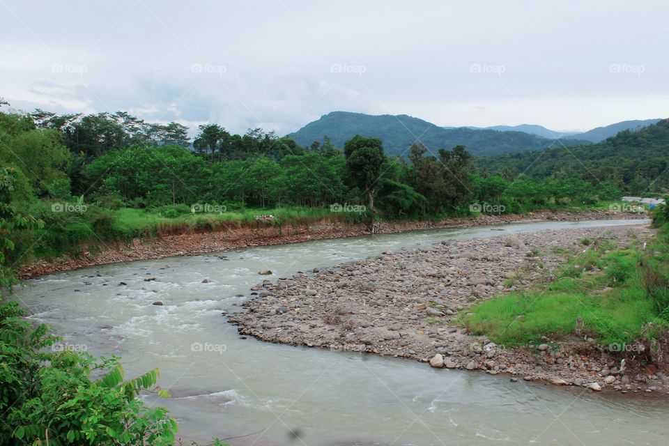 it looks like there is a landslide that is eroded by the river flow so that the river flows into a bend