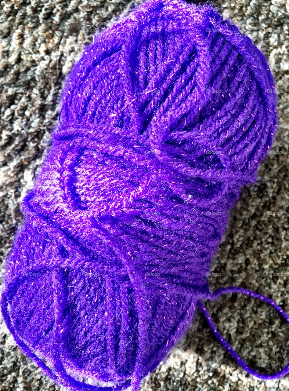 Messy ball of purple sparkle yarn
