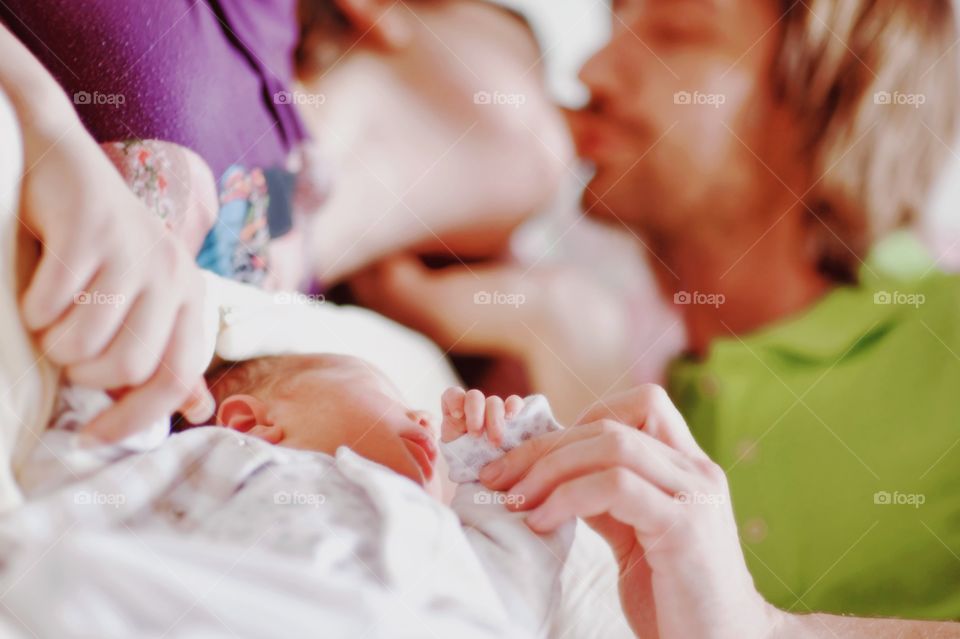 Family with new born baby sleeping on bed