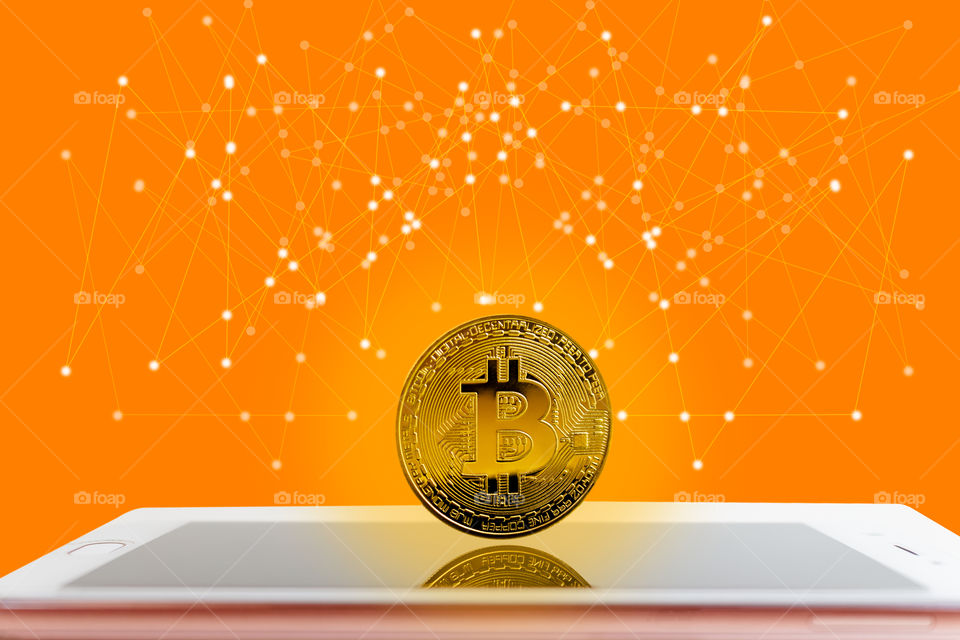 Golden digital bitcoins Currency stand on smartphone Digital Network and society orange tone background.
