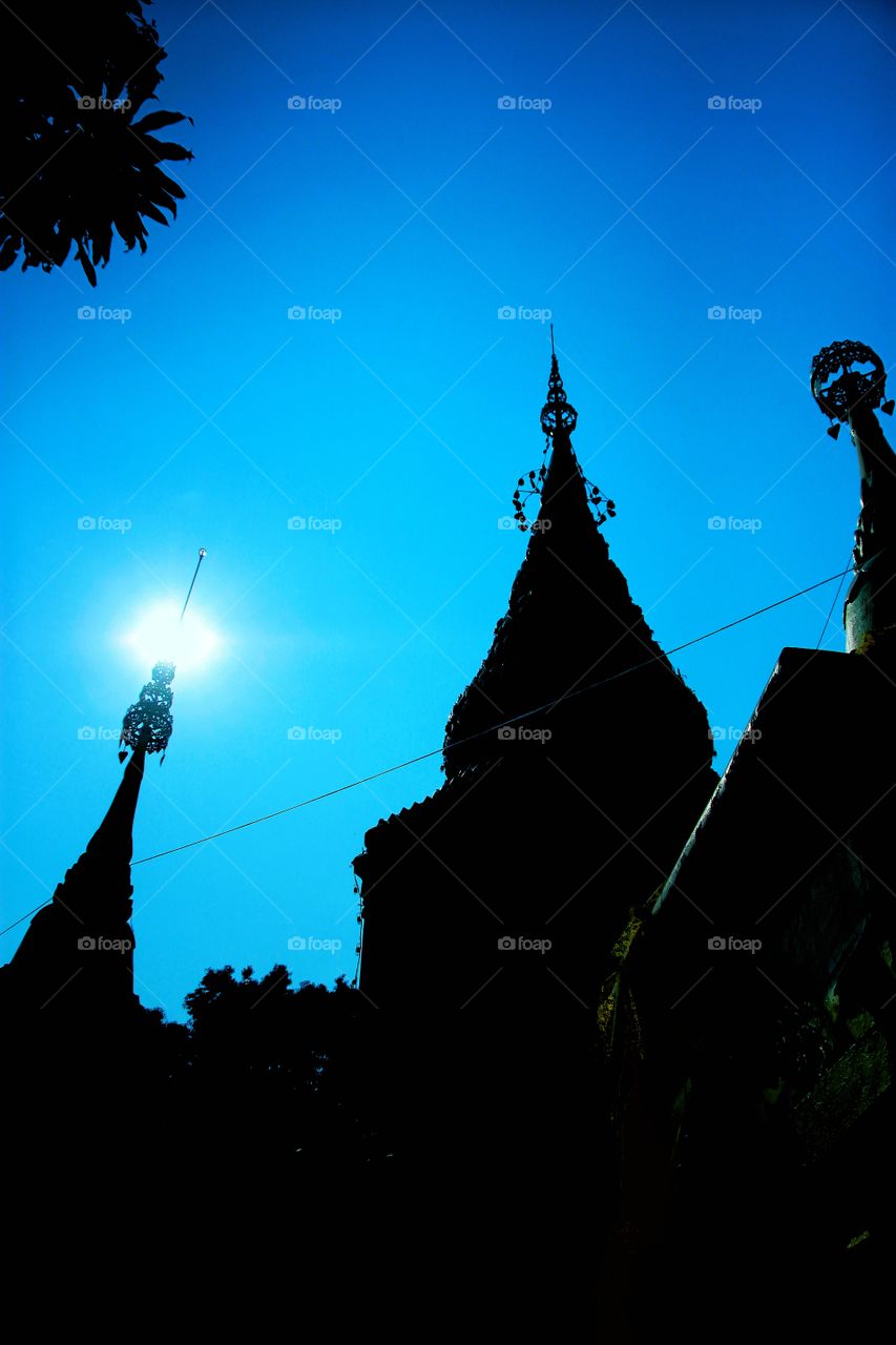 Light from the sun shining down against the backlit photos of the Chedi in Thai temples.  Gives the light a shadow of a beautiful shape. Light an shadow.