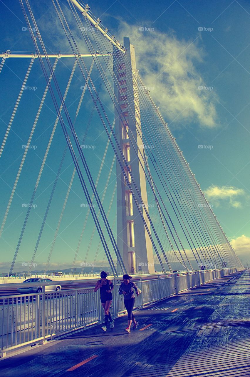 Morning ritual . 2 people running on bridge