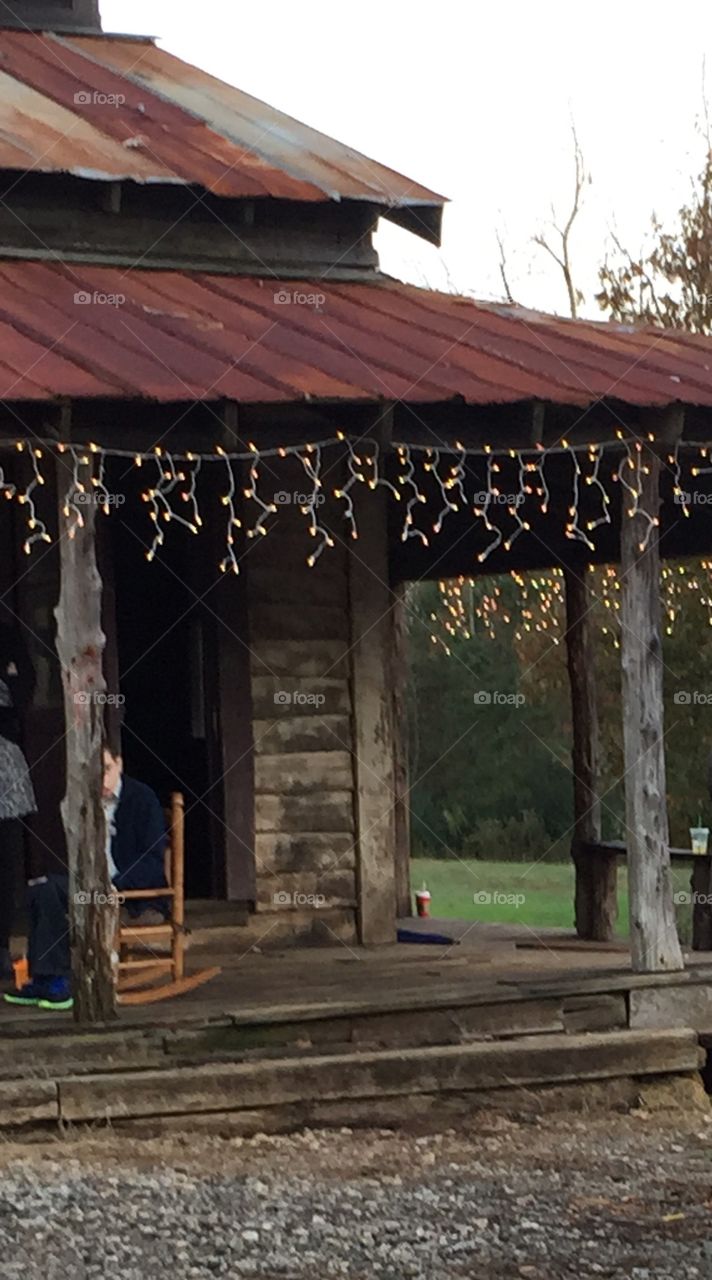 Old wood building used for a movie set in the country showing porch and partial view of rocking chair.