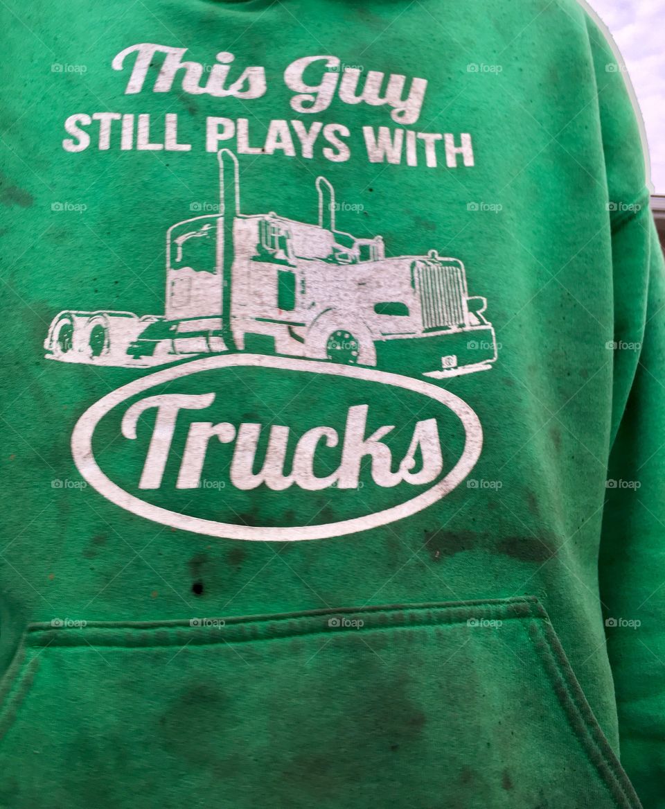 Scrap Metal truck driver wearing his Green hoodie with the saying, "This Guy Still Likes to Play with Trucks"