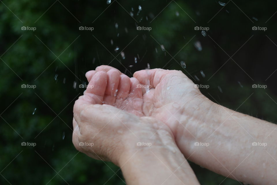 water drops in the hands green background, splash summer time