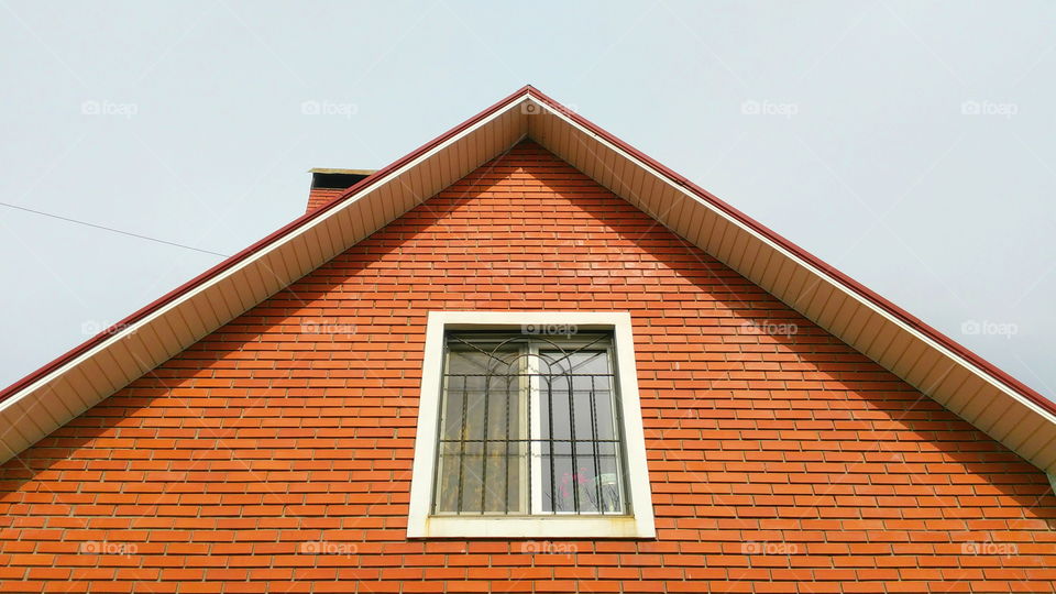 roof of a brick house with a window