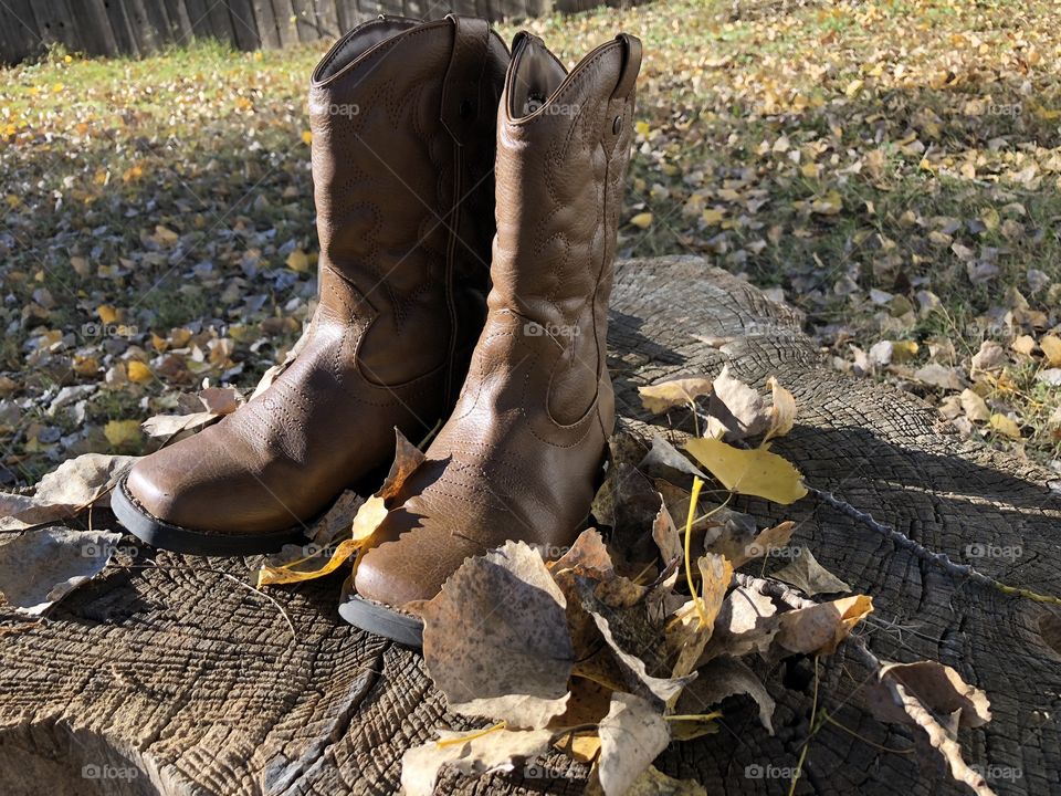 Forgotten cowboy boots of a child with bare feet somewhere