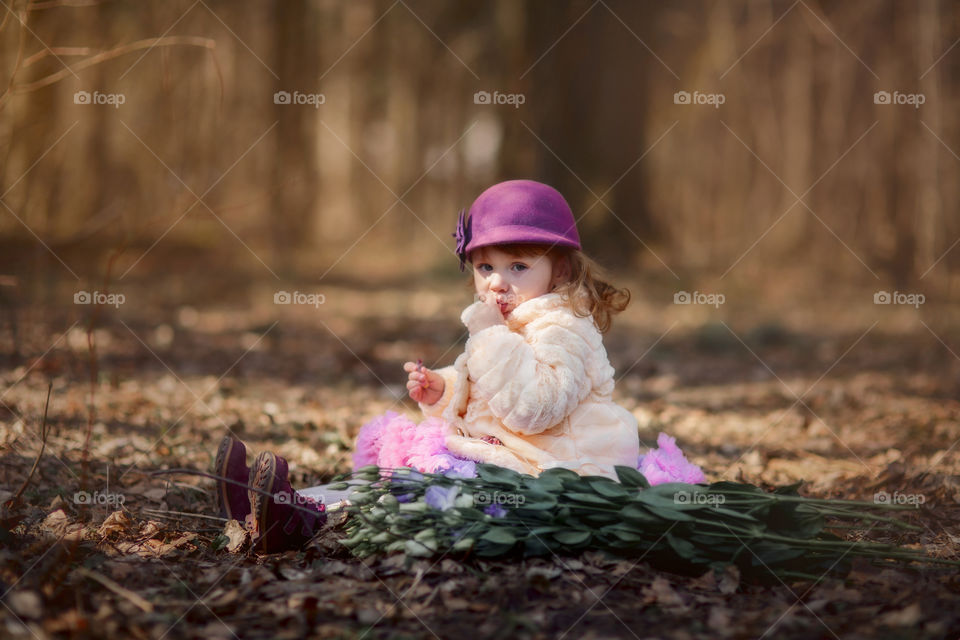 Little girl with bouquet of eustoma  flowers in spring park