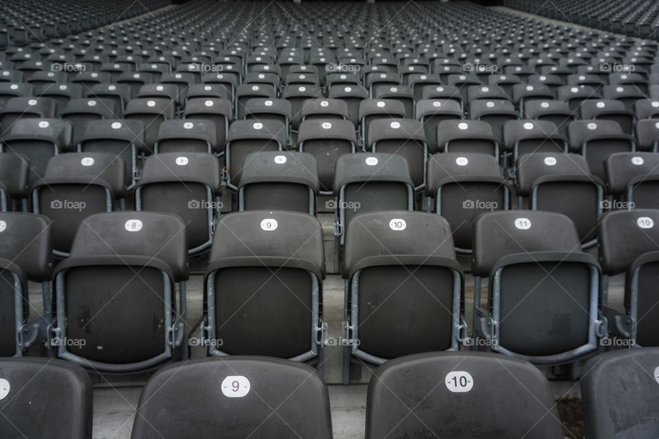 Colour black Mission .... rows and rows of seats in a stadium 