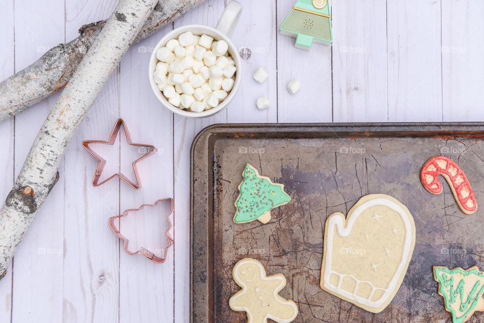 Rustic flat lay of assorted homemade Christmas cookies on a baking sheet