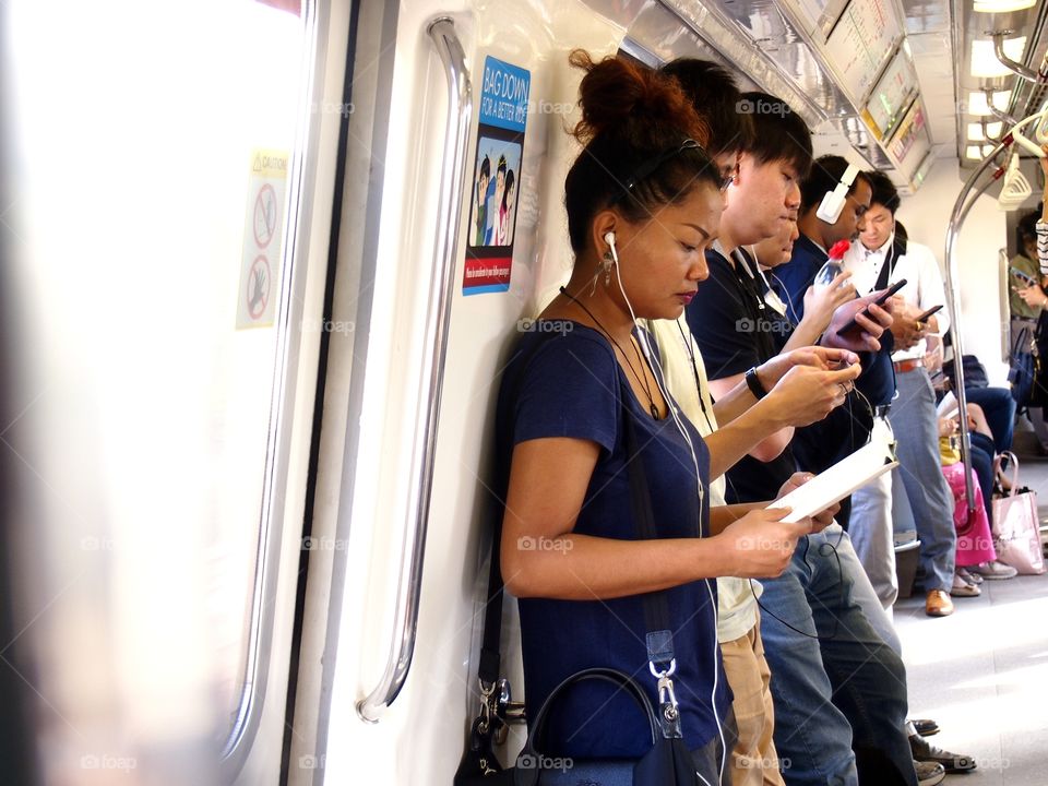 passengers inside a train using smartphone or cellphone