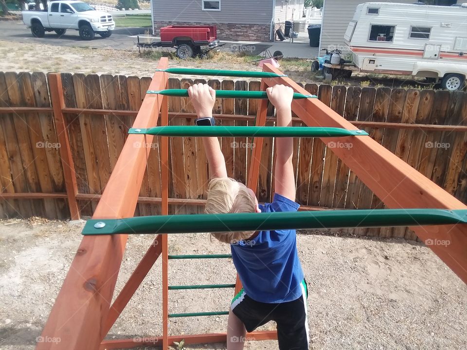 child doing monkey bars