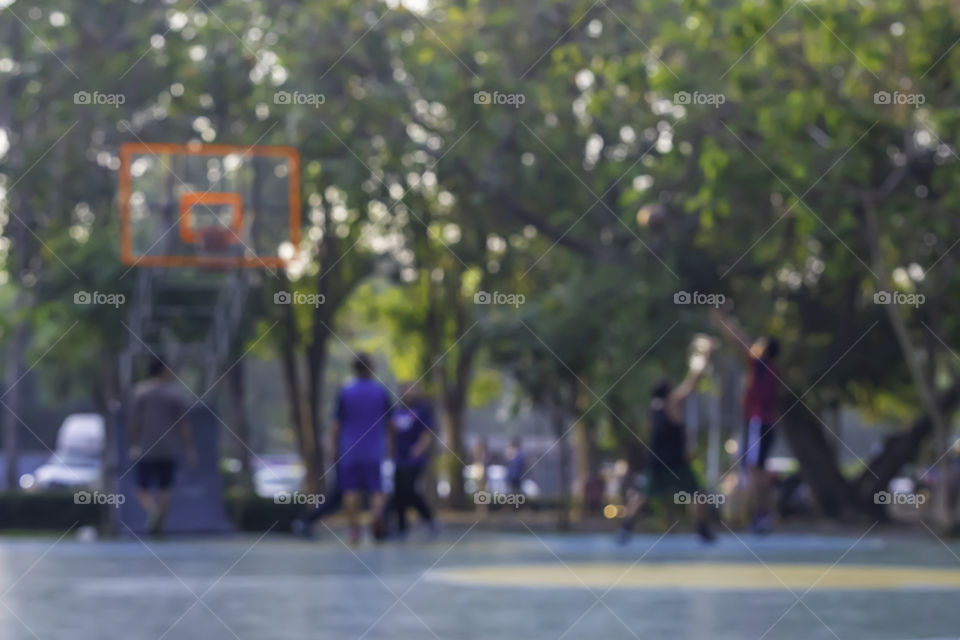 Blurry image of elderly men and women playing basketball in the morning.