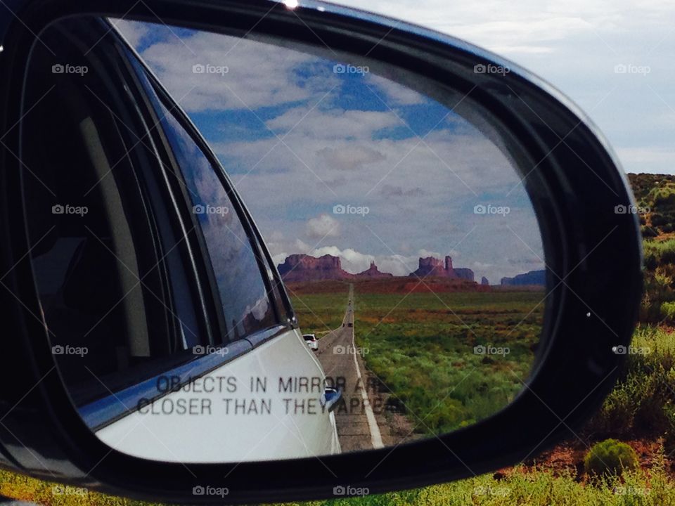 the monument valley skyline seen from the rearview mirror along the I163