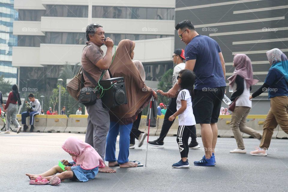 if people can move from one spot to another, this family don't. this is the picture of a disability family who begging while singing at Car free day in Jakarta. (September 15, 2019)
