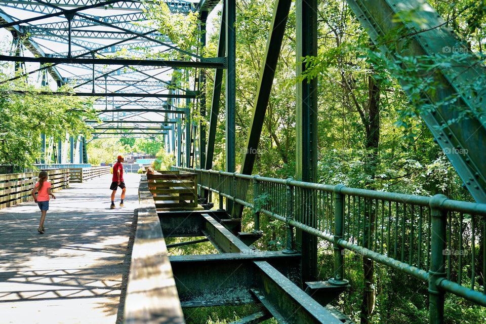 Sister tries to catch up to big brother on a walk along the bridge on the Greenway.