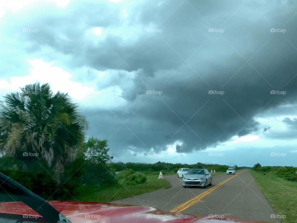 Road trip going towards the beach in central eastern Florida by the Atlantic Ocean meeting some cars on the opposite side of the road.