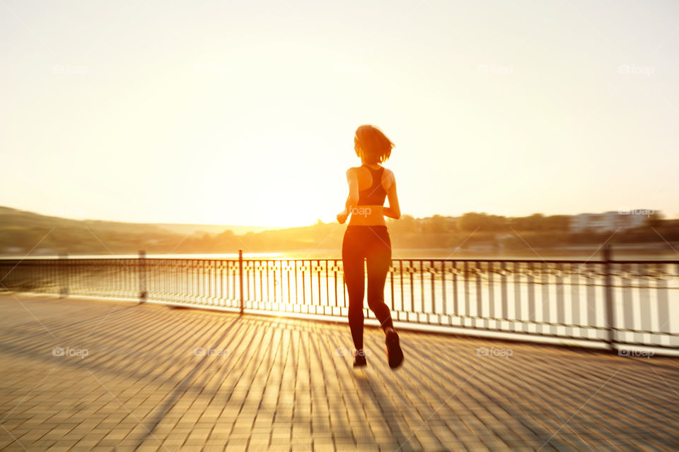 Rear view of girl running on sidewalk