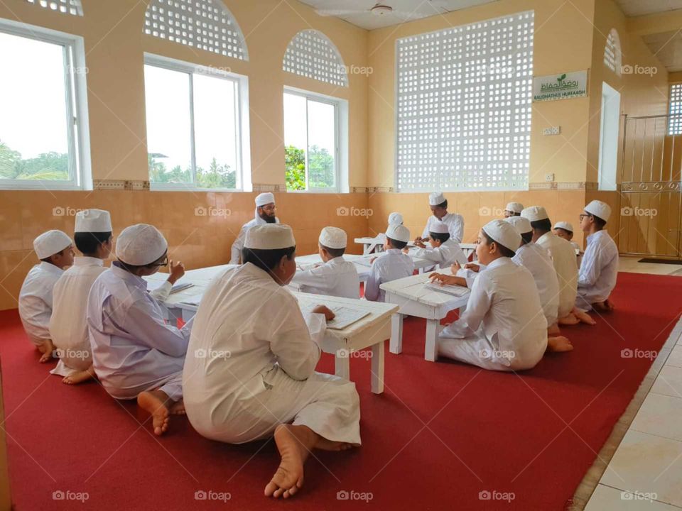 Muslim children studying arabic and reading Quran,