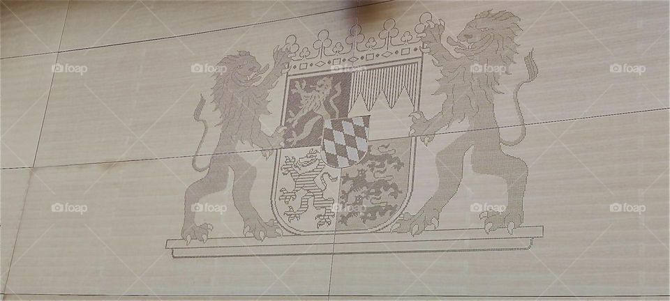 The heraldic symbol for „Bavaria” is shown at the “Maximilianeum”, seat of the “Bavarian State Parliament” in “Munich”: Two lions hold a crowned shield showing a lion, three smaller ones, a dragon and the flag w trapezoids. 2024. Hypnotic Productions